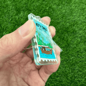 Peeling off protective film from acrylic keychain to reveal scratch-free surface